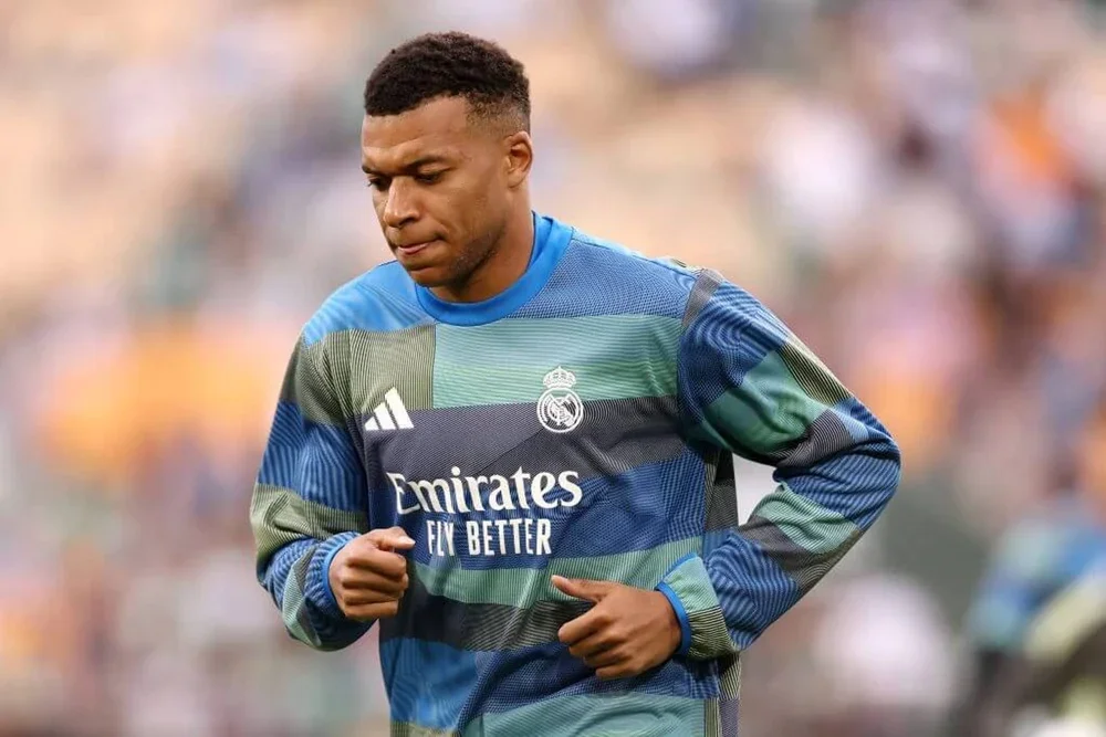 Kylian Mbappe wears a Real Madrid training top as he jogs prior to a match