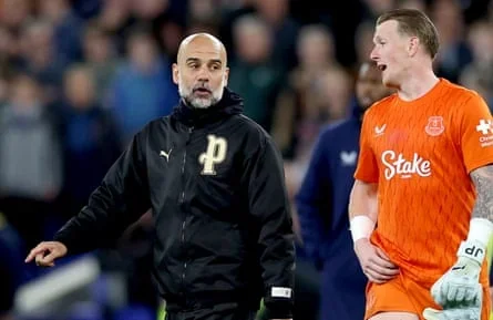 Manchester City manager Pep Guardiola talks to Everton goalkeeper Jordan Pickford