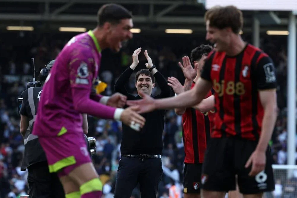 Andoni Iraola applauds the fans while his Bournemouth players celebrate victory at Fulham